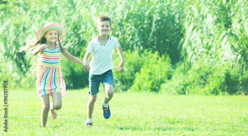 two enthusiastic children active playing and running outdoors