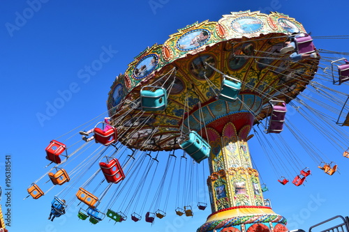 Colorful carnival ride at amusement park, summer day.