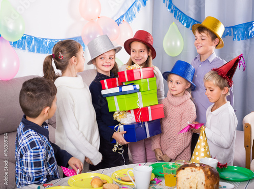 positive children giving presents to girl during party
