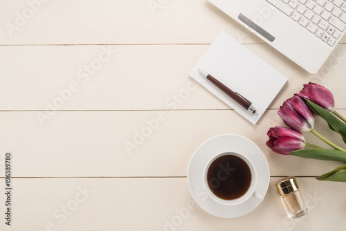 Office table with cup of coffee and flowers