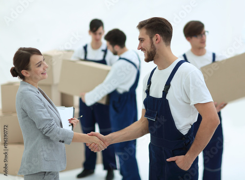 Manager with clipboard shaking hands with movers.