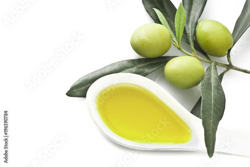 Branch with olive leaves and olives on wooden table