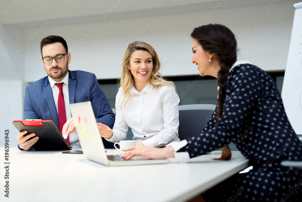 Group of business partners discussing ideas and planning work in office Group of business partners discussing ideas and planning work in office