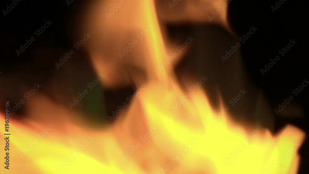 Flickering orange flames burn in a blazing fire. Flickering orange flames burn in a blazing fire.