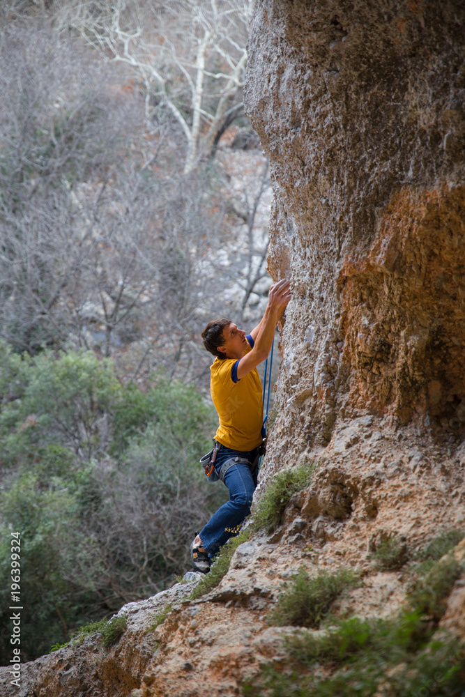 Obraz premium rock-climber climbs route with lower insurance 