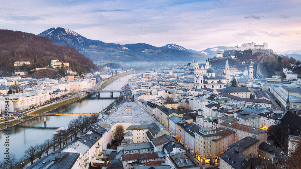 Salzburg, Austria. Aerial panoramic view of famous historic city of Salzburg with Hohensalzburg Fortress and Salzach river in twilight, Salzburger Land, Austria, Europe.