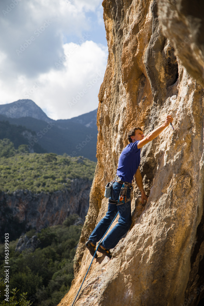 Fototapeta premium rock-climber climbs route with lower insurance 