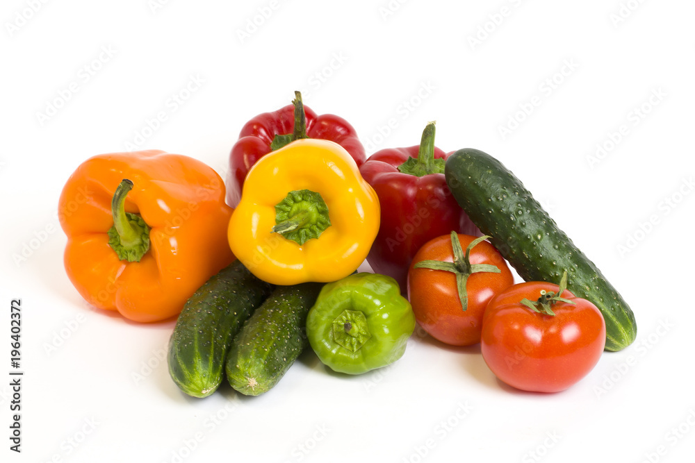 Red yellow and orange peppers with tomatoes on a white background. Cucumbers with colorful peppers in composition on a white background.
