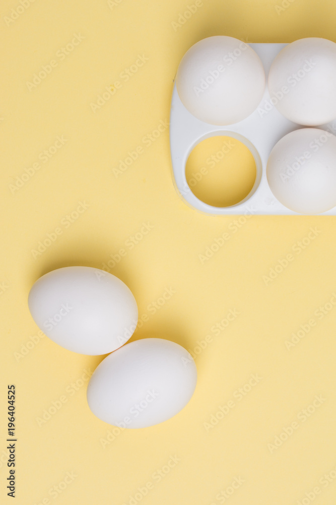 Happy Easter concept. White eggs on yellow background close up. Flat lay. Minimal concept. Top view. Design, visual art.