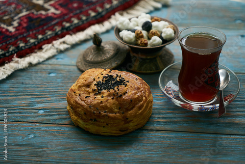 Novruz holiday with Azerbaijan national pastry Gogal and glass of black tea on rustic wooden table background, Delicious dessert holiday food