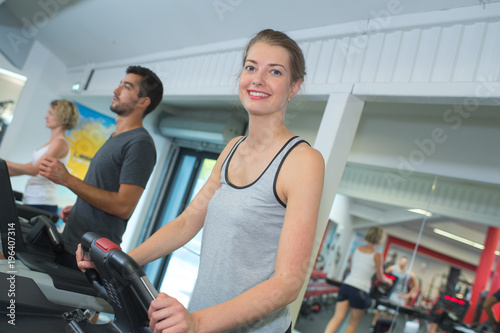positive people training on the exercise bikes in fitness club