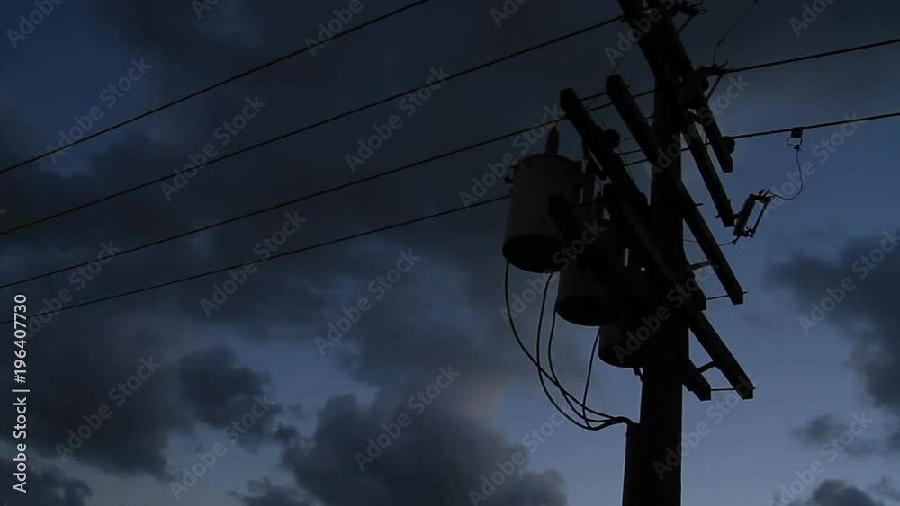 Power lines silhouetted against a dark sky. 