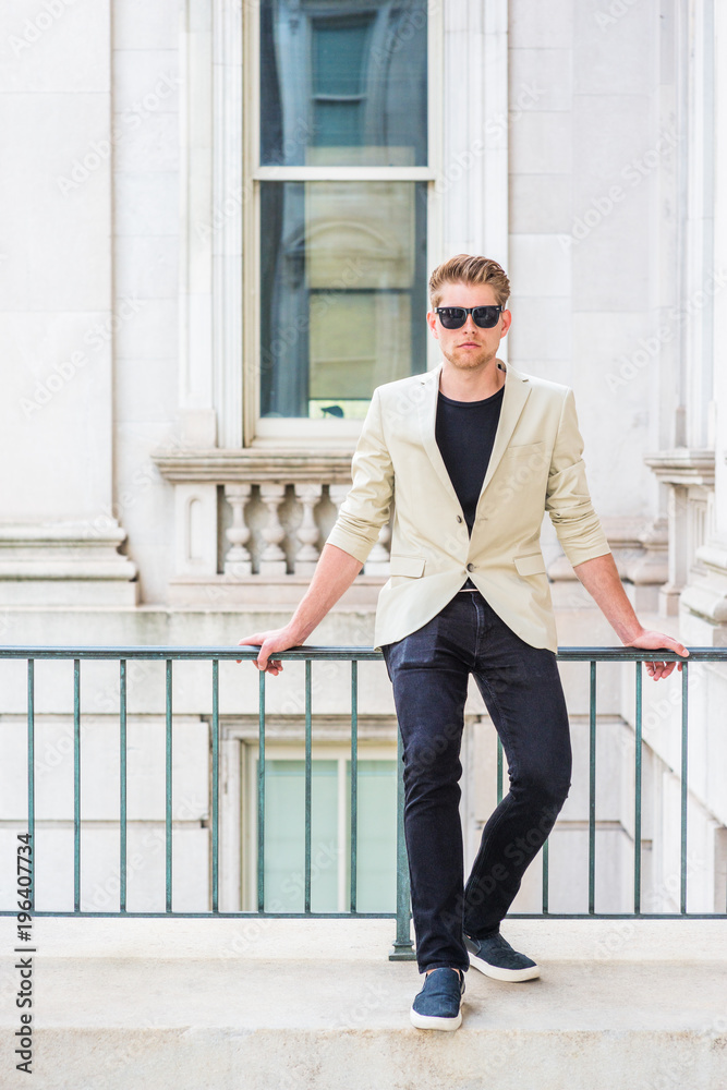 Young American Businessman Casual Fashion in New York, wearing beige blazer,  black undershirt, black pants, casual shoes, sunglass, sitting on railing  in vintage office building.. Stock Photo | Adobe Stock