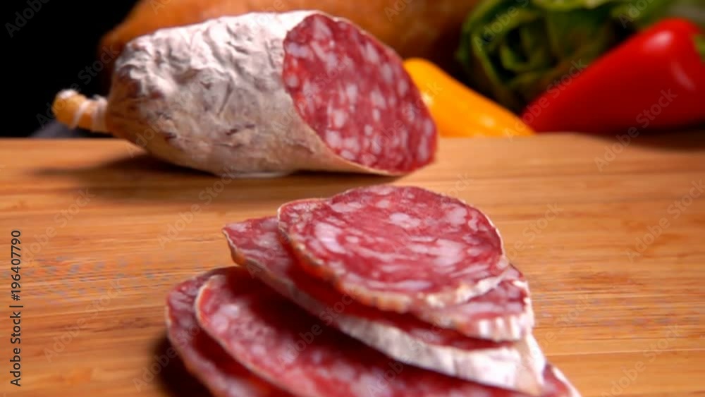 Slices of smoked spase sausage falls on a wooden board Slices of smoked spase sausage falls on a wooden board