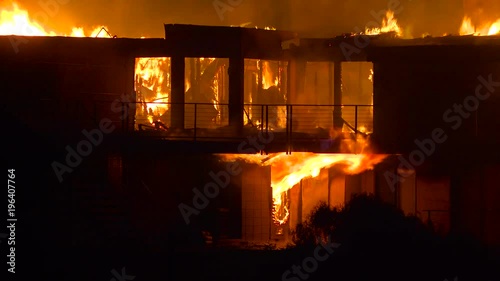 Close up of a home burning in a large inferno at night during the 2017 Thomas fire in Ventura County, California. photo