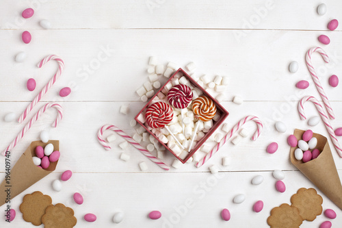 Frame Candies, cookies,Marshmallows and Lollipops Gift Top view White wooden Background