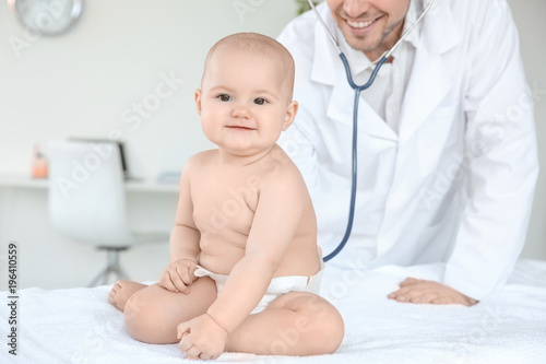Doctor examining cute baby ...