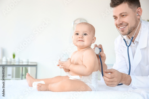 Doctor examining cute baby ...