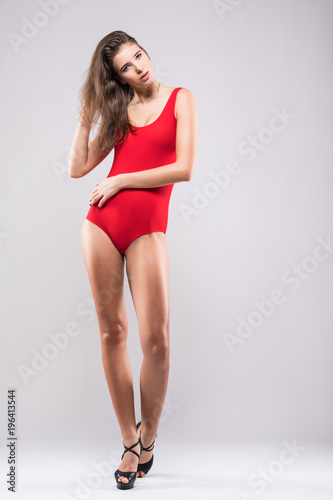 Full body of perfect slim woman wearing red swimsuit isolated on gray background