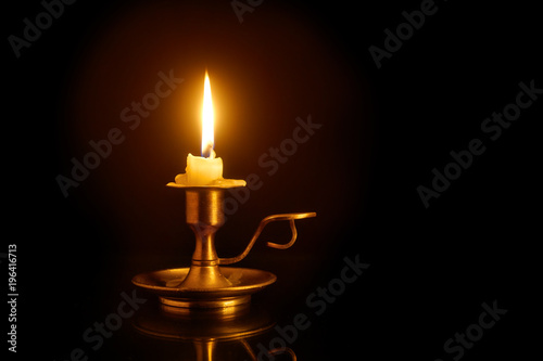 Obraz na plátně Burning candle on candlesticks