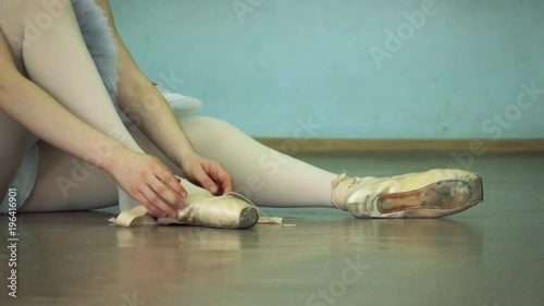 Slow motion footage. Ballerina wears ballet shoes on the background. Dansing foreground