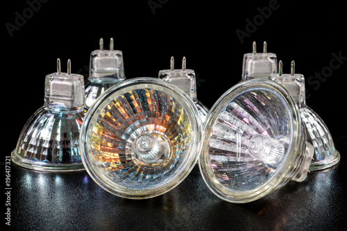 Halogen bulb in a reflective shade. Lighting accessories on a dark tole.