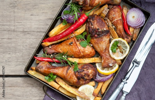 Grilled spicy chicken legs with pepper, lemon and potatoes photo