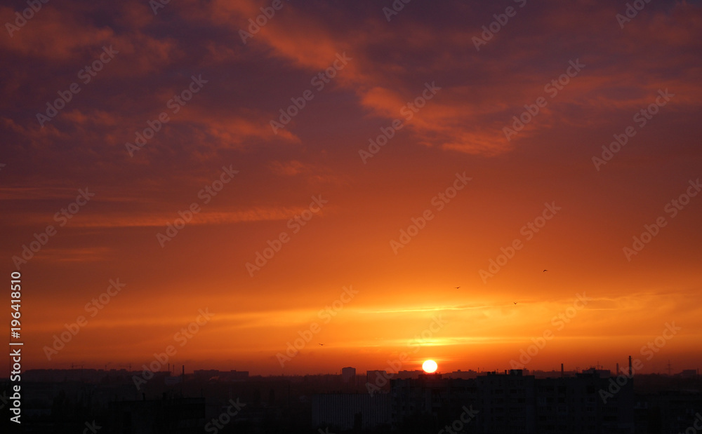 Red sunset over the city. Sunset. Red blue clouds at sunset. Panorama of the sunset