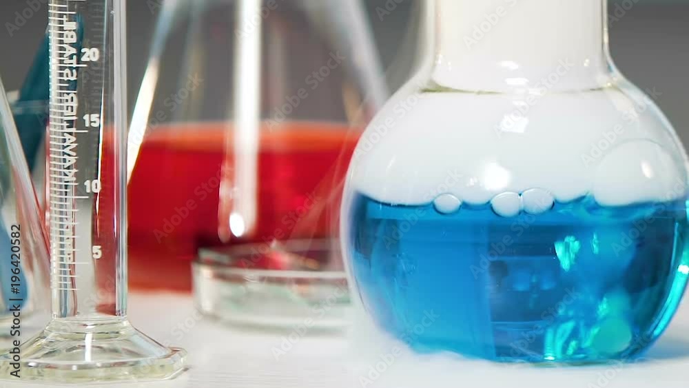 Blue chemical substance with smoke boils in laboratory, chemical experiment