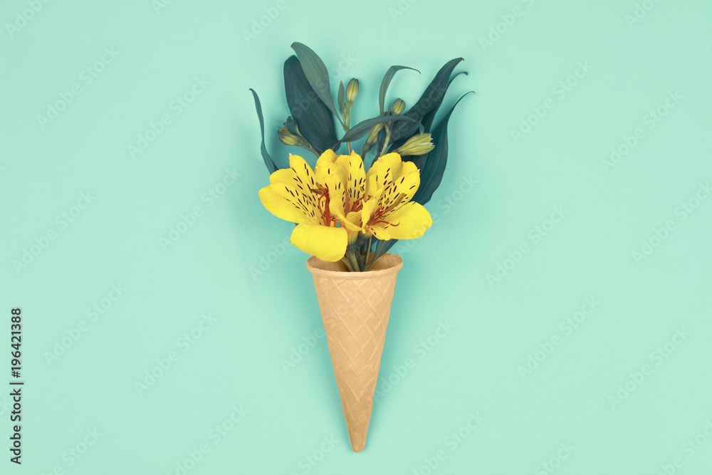Spring is coming. Bouquet of yellow flowers with green leafs in waffle cones on design blue background