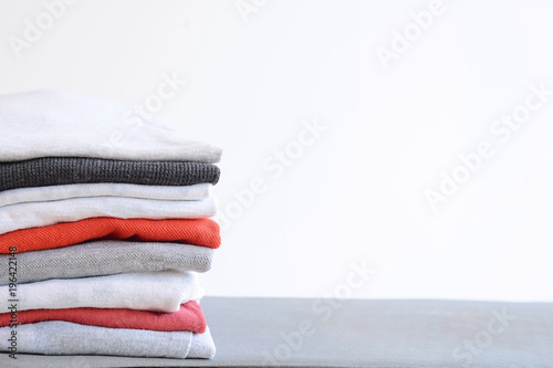 Foto Stack of colorful folded shirts on gray table