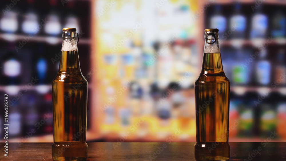 Two bottles of beer, a bar counter.