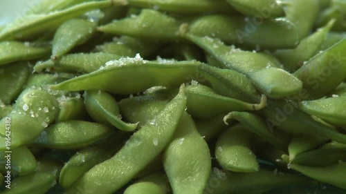 Close up pan of salted organic soy bean pods photo