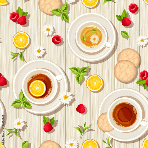 Vector seamless pattern with cups of tea, cookies, lemons, raspberries and leaves on a wooden background.