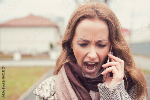 Screaming woman having phone converstation outside photo