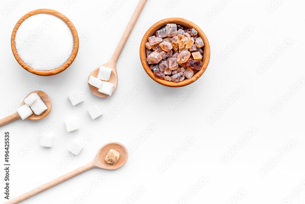 Brown and white sugar in bowls, scoop and spoon. Cane, refind, granulated, cubes, candy. White background top view copy space Brown and white sugar in bowls, scoop and spoon. Cane, refind, granulated, cubes, candy. White background top view copy space