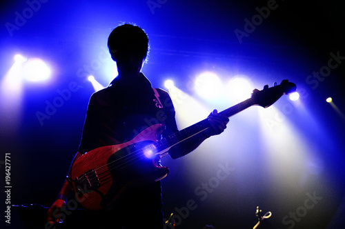 Silhouette of an unrecognizable man playing an electric guitar