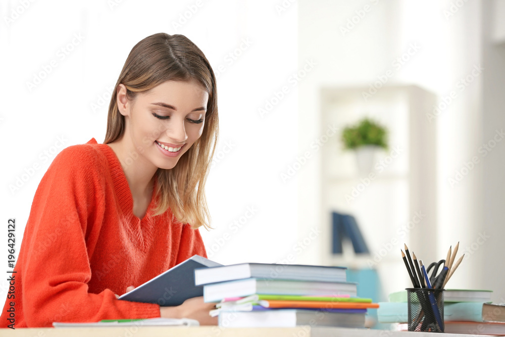Pretty student studying at table indoors Pretty student studying at table indoors