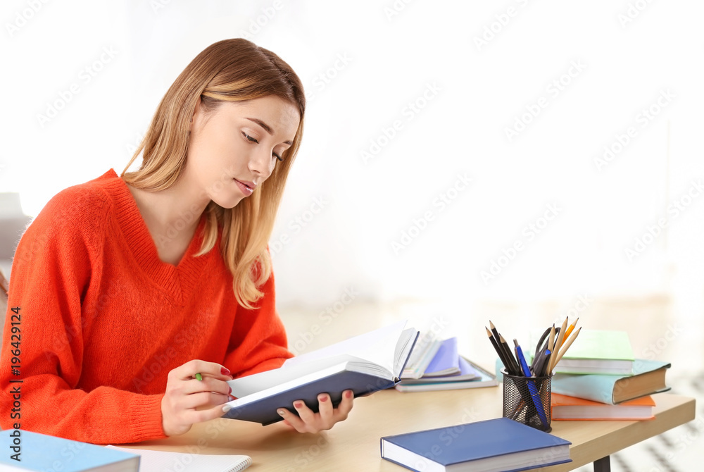 Pretty student studying at table indoors Pretty student studying at table indoors