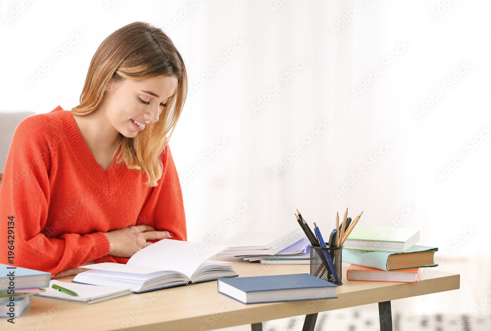 Pretty student studying at table indoors Pretty student studying at table indoors