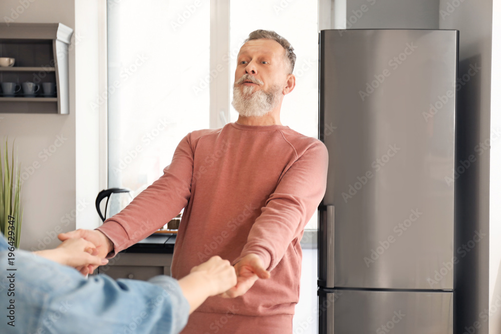 Happy mature couple dancing in kitchen Happy mature couple dancing in kitchen