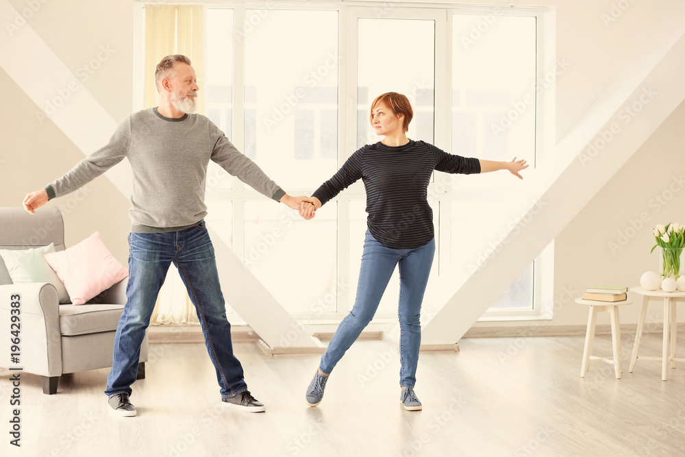 Fototapeta premium Happy mature couple dancing at home