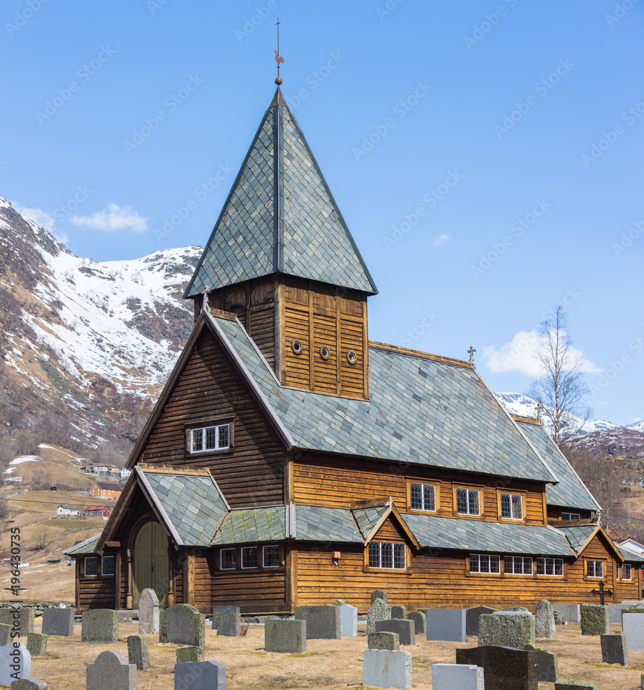 Roldal Stave Church (Roldal stavkyrkje) with snow cap mountain background