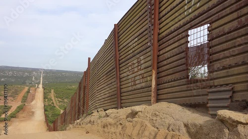 The U.S. Mexico border wall fence which has a hole or window in it. photo