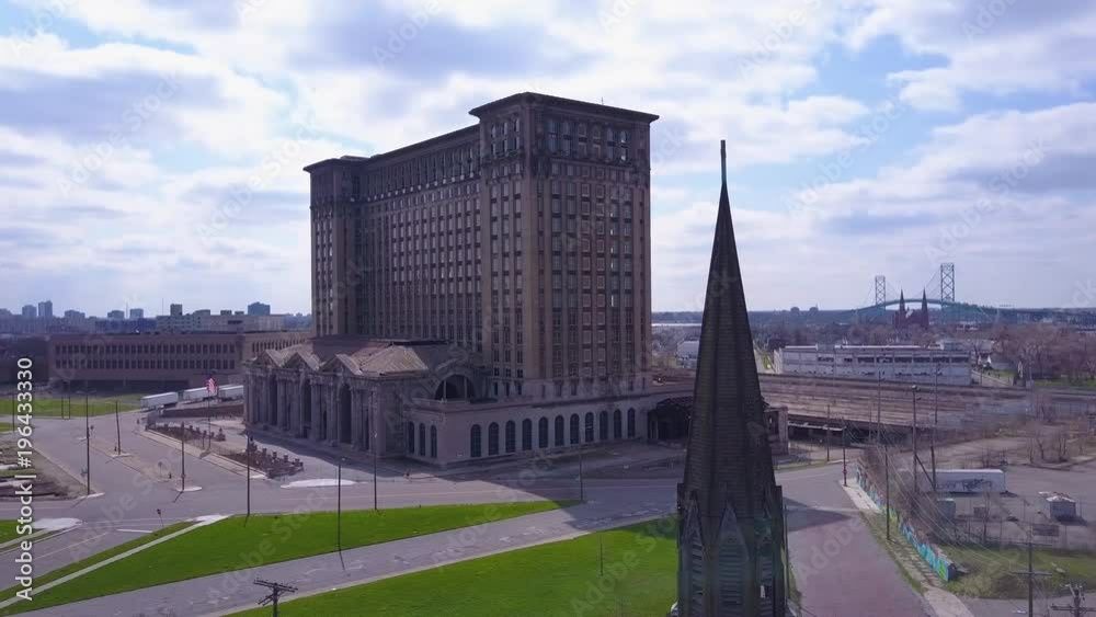 Aerial of the exterior of the abandoned central train station in Detroit, Michigan includes church steeple foreground.. Aerial of the exterior of the abandoned central train station in Detroit, Michigan includes church steeple foreground..