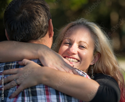 woman looks at you and smiles while giving a hug