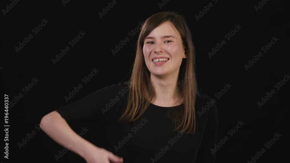 A beautiful young lady showing a Call me gesture against a black background. Medium Shot A beautiful young lady showing a Call me gesture against a black background. Medium Shot