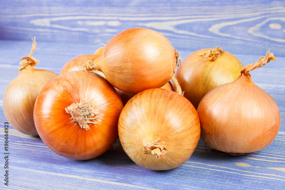 Heap of onions on purple boards, healthy nutrition Heap of onions on purple boards, healthy nutrition