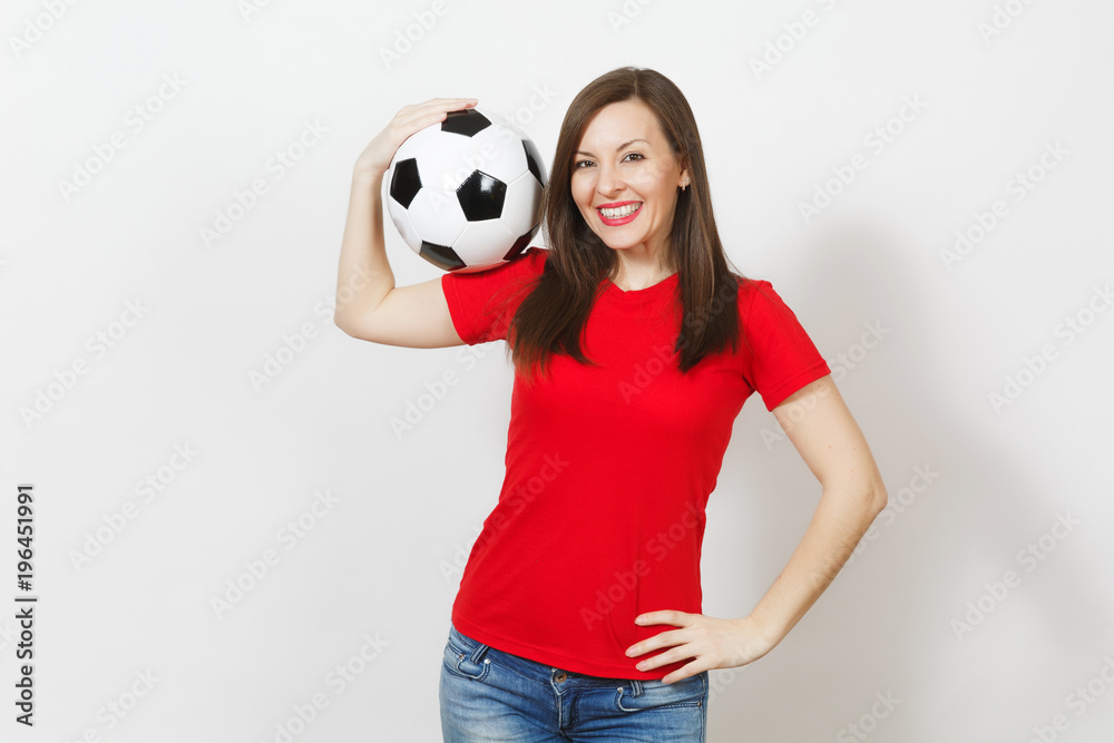 Beautiful European young cheerful happy woman, football fan or player in red uniform holding classic soccer ball isolated on white background. Sport, play football, health, healthy lifestyle concept.