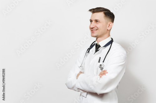 Smiling happy confident experienced handsome young doctor man isolated on white background. Male doctor in medical uniform, stethoscope looking aside. Healthcare personnel, health, medicine concept.